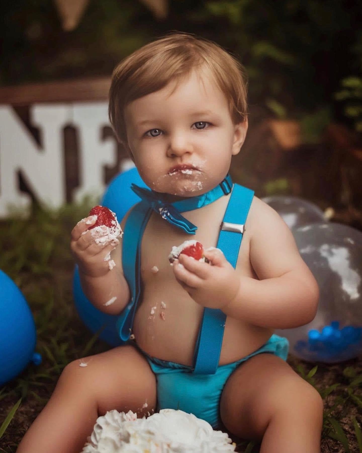Toddler at first birthday cake smash